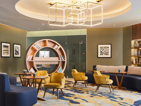 A hotel lobby featuring blue and yellow furniture, creating a vibrant and welcoming atmosphere for guests.