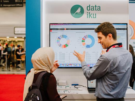 A man and a woman reviewing a screen of data.