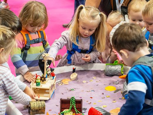 Children joyfully playing with colorful toys in a vibrant play area, engaging in imaginative activities together.