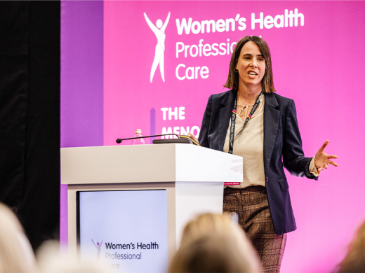 A woman stood at a podium, delivering a presentation at a conference.