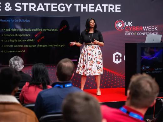 A woman delivering a presentation at a conference.