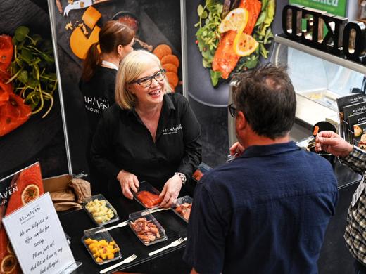 A woman smiling at a man, surrounded by food,