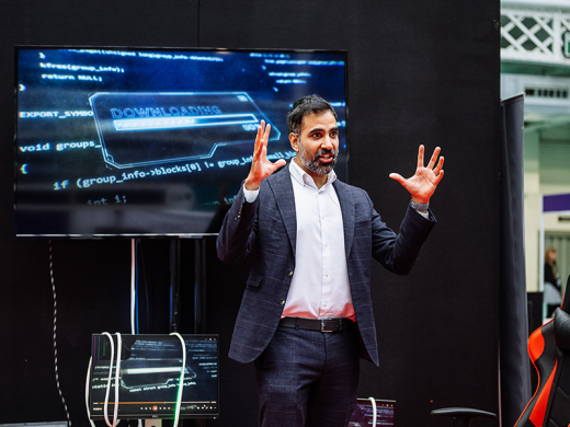 A man on stage presenting at International Cyber Expo