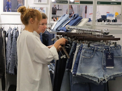 Two women going through railings of clothes at Fashion SVP