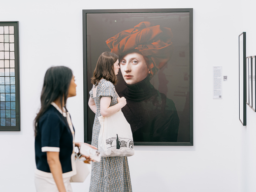 Two people walking around Photo London engaged in the photography on display
