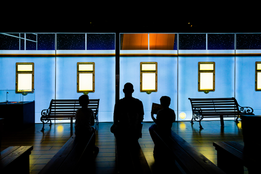 Shadows of people looking at a dark screen with the Titanic on