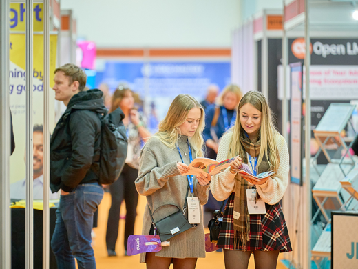 Two girls looking at show magazine