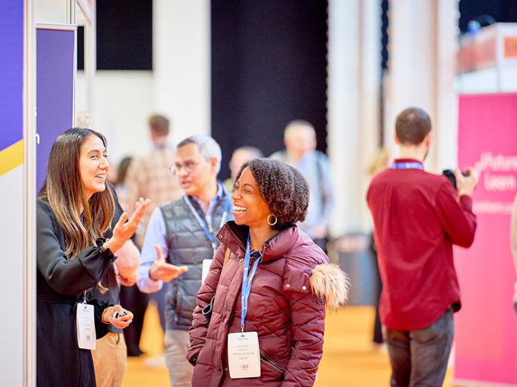 Two women engaged in conversation at a social event, sharing ideas and enjoying the moment together.