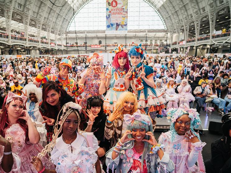 A lively convention scene featuring a group of people dressed in various costumes.