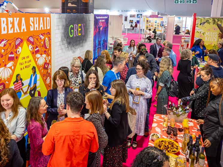A diverse crowd of attendees engaging and networking at a bustling trade show event.