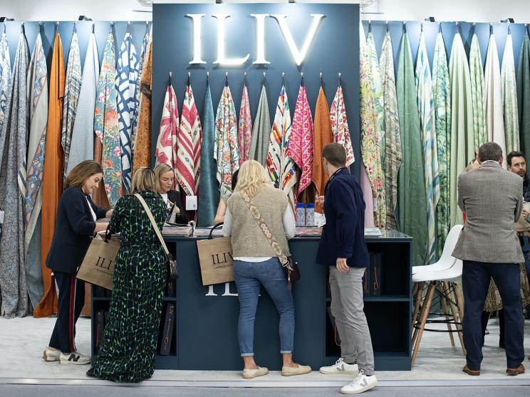 People gathering around show stand at decorex taking an interest in the samples