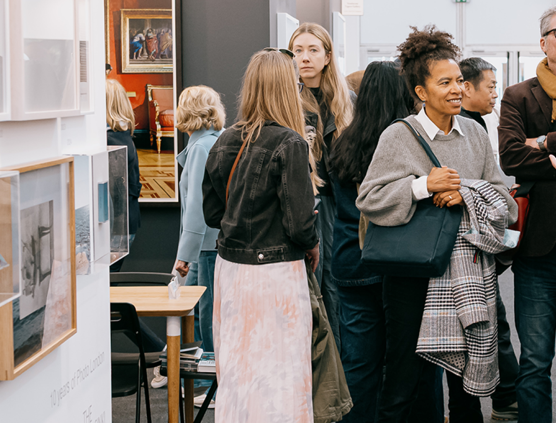 People gathered around photography pieces at Photo London