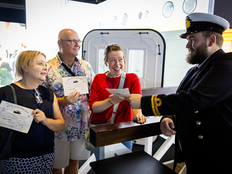 Group of people smiling at a man dressed in sailor costume