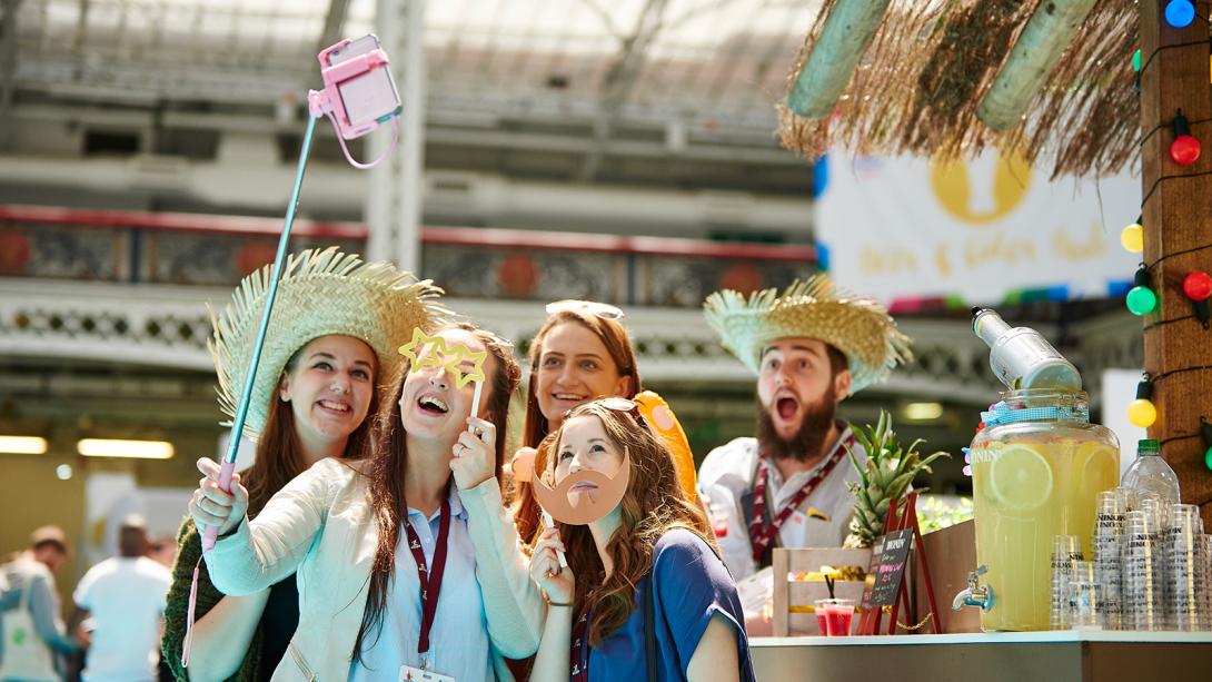 Group of visitors taking a picture at an event using a selfie stick