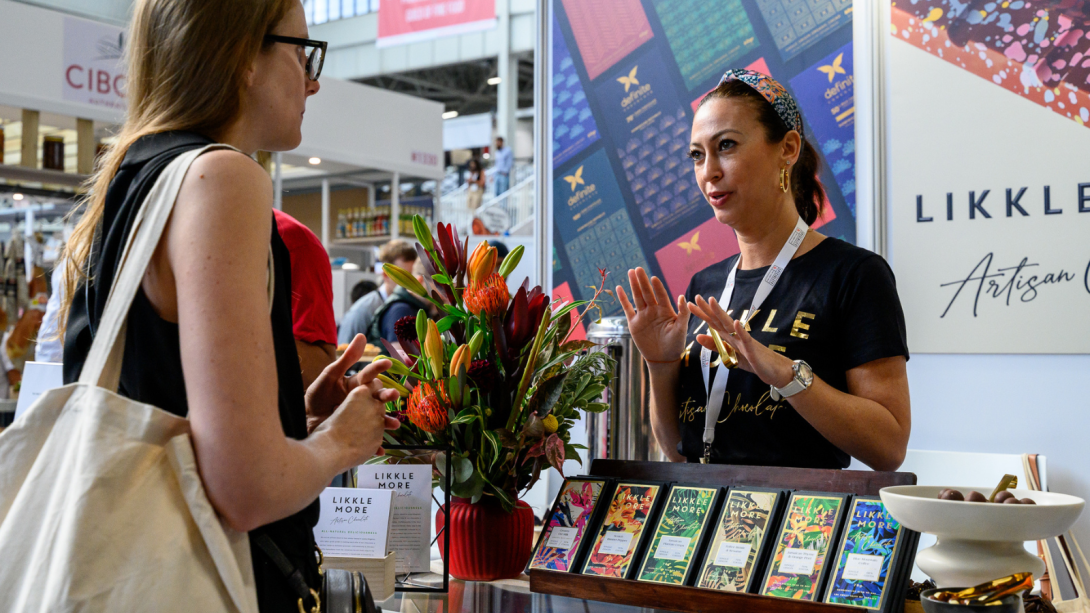 Two women chatting at a booth.