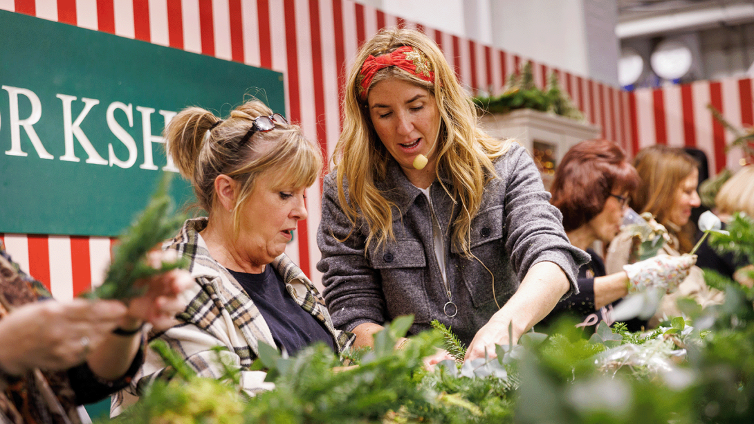 Two women partaking in a wreath making workshop.