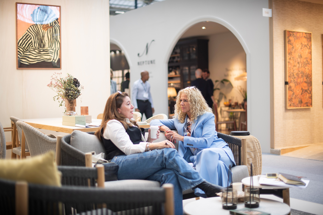 Two women talking on a sofa at Decorex