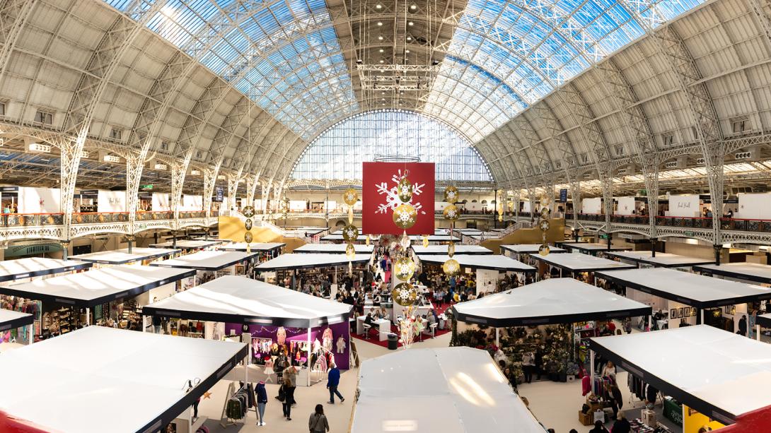 A festive indoor market showcasing a crowd of people engaging in shopping and browsing activities.