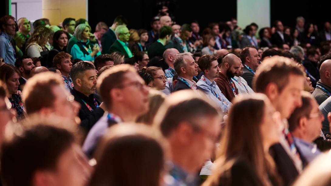 Individuals at a conference listening to a presentation