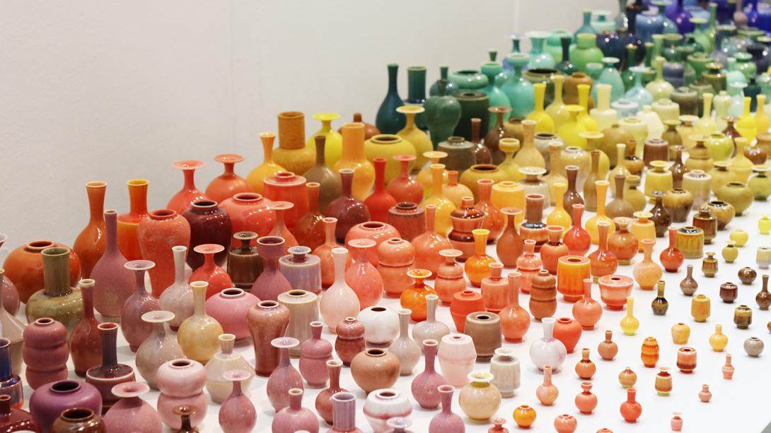 A collection of colorful vases arranged neatly on a table, showcasing their unique designs.