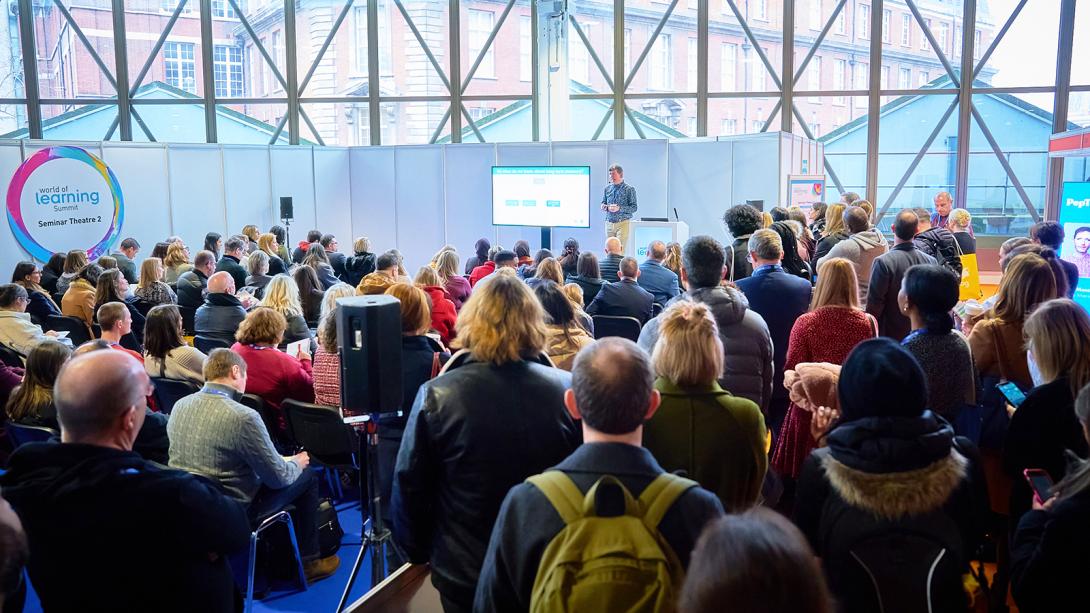 A bustling crowd fills a vast room, highlighting the energy and interaction among a multitude of attendees.