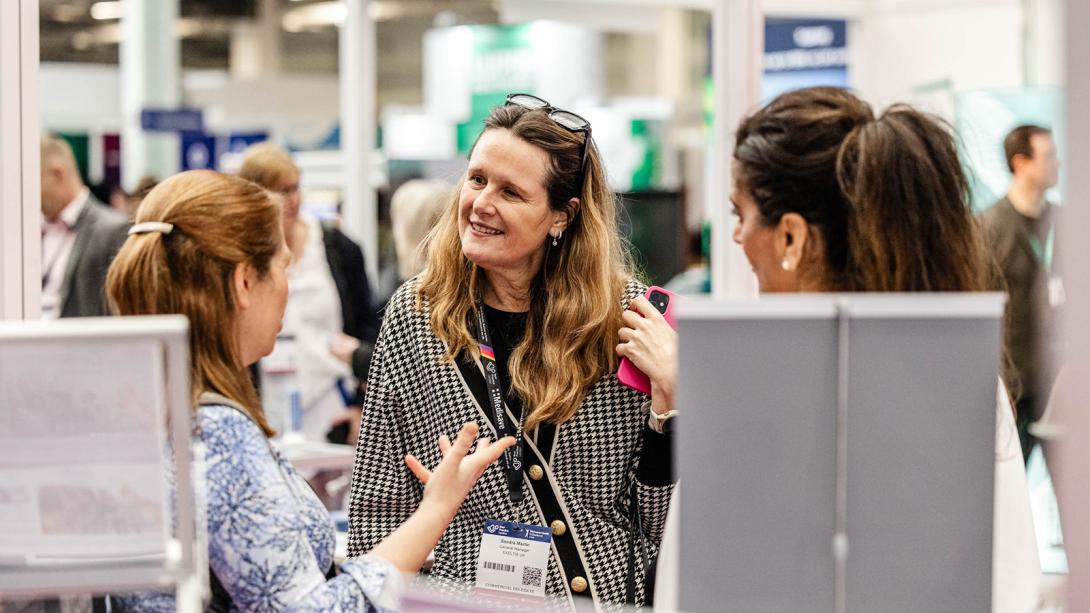 Two women engaged in conversation at a trade event.