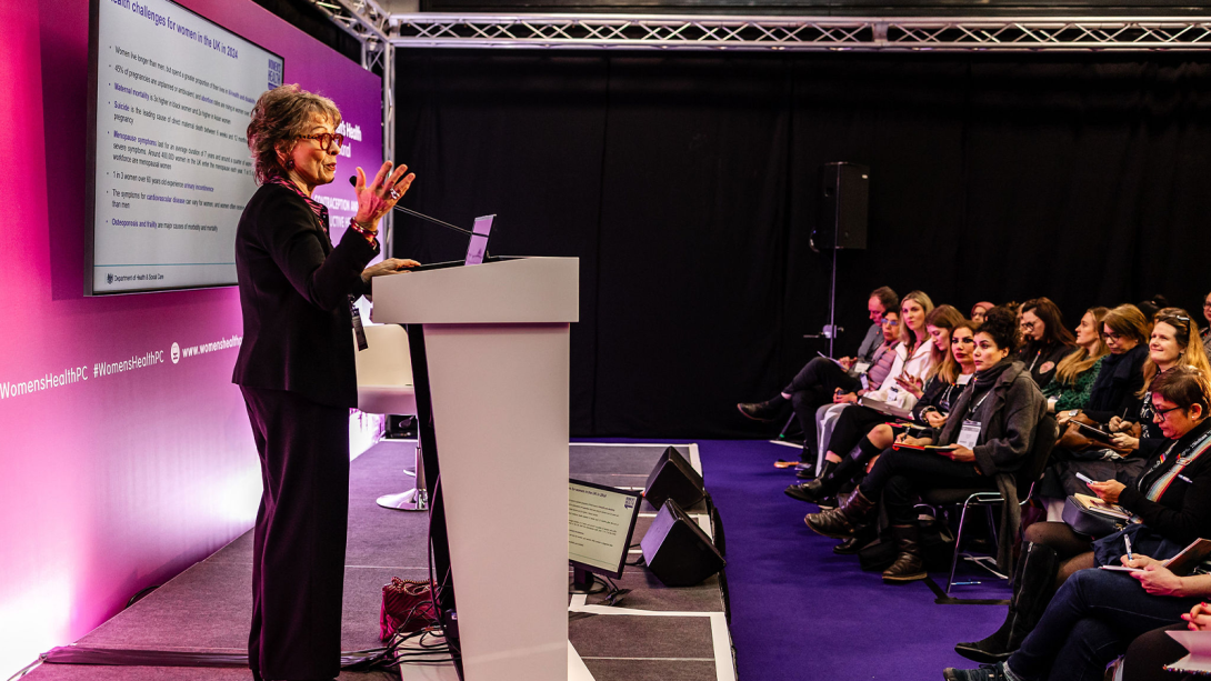 A woman confidently presenting at a conference.