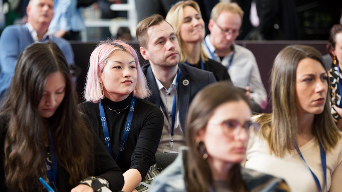 A diverse group of individuals engaged in a presentation at a conference.