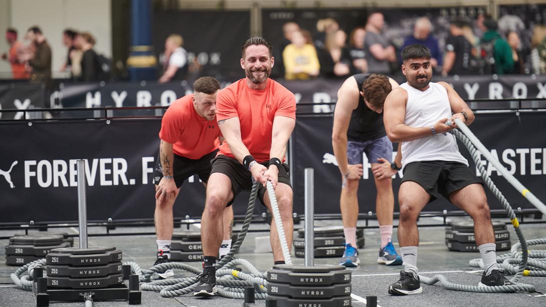 Four men participating in a fitness challenge, demonstrating strength and teamwork.