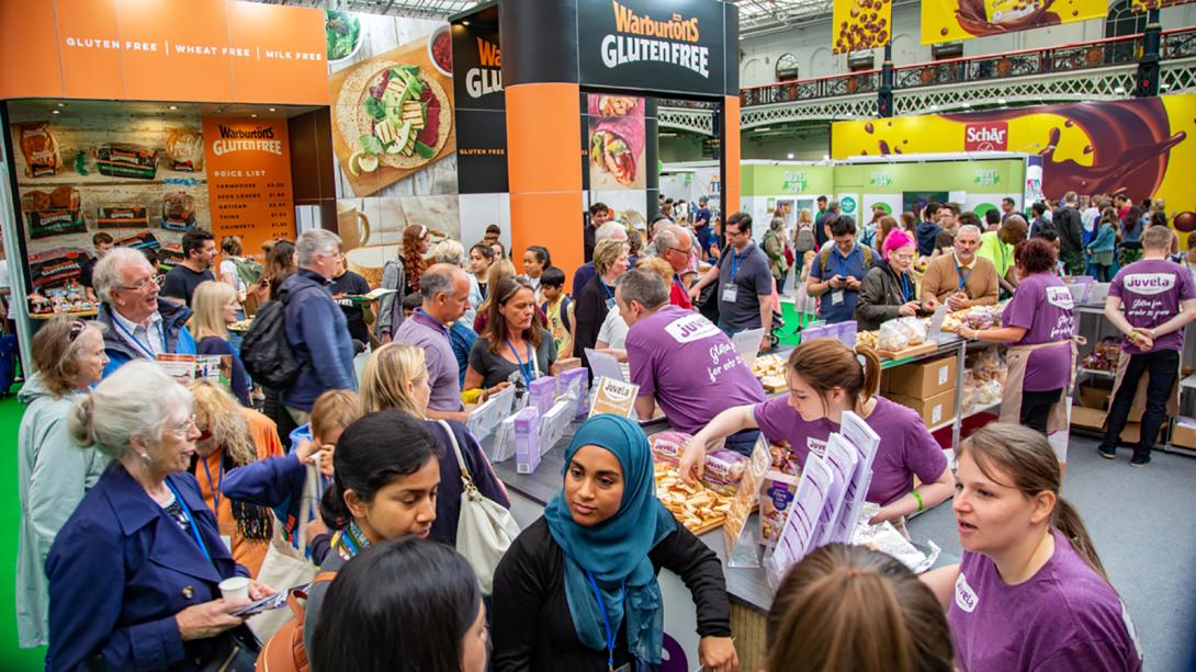 Crowd gathering around a stand at the Allergy and Free From Show taking an interest in the products