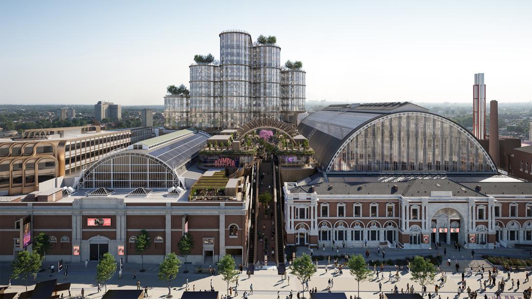 Aerial view of Olympia London showing the iconic arched exhibition halls alongside new glass tower structures and rooftop gardens, illustrating the site's transformation into a modern cultural destination.