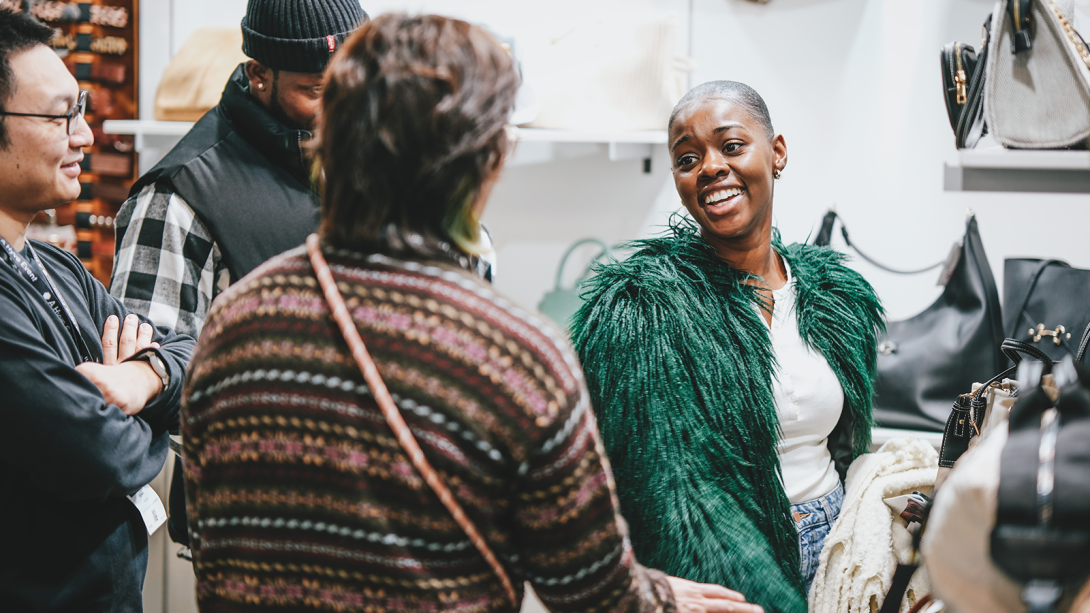 Two people looking at the fashion on display touching the fabric