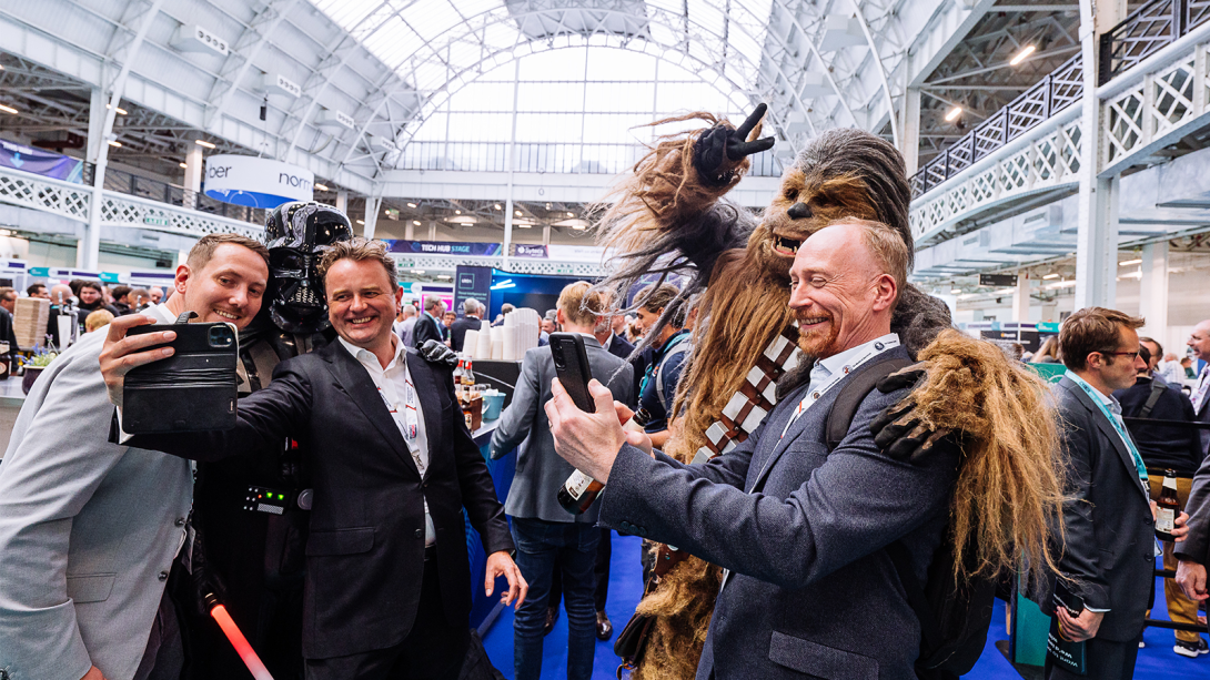A group of enthusiastic Star Wars fans dressed in costumes smiling for a photo at International Cyber Expo