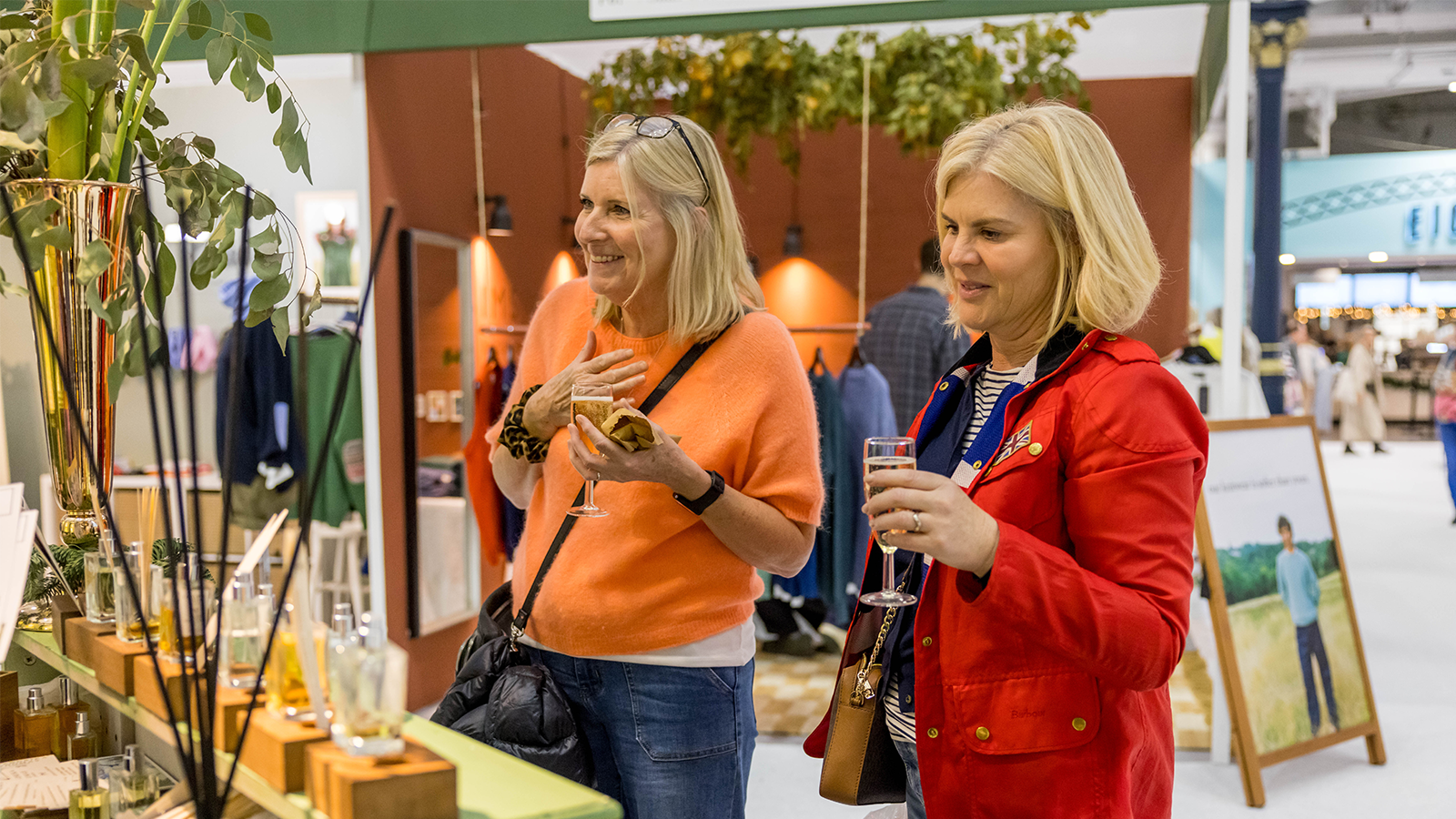 Two women standing side by side engaged in the products on display 