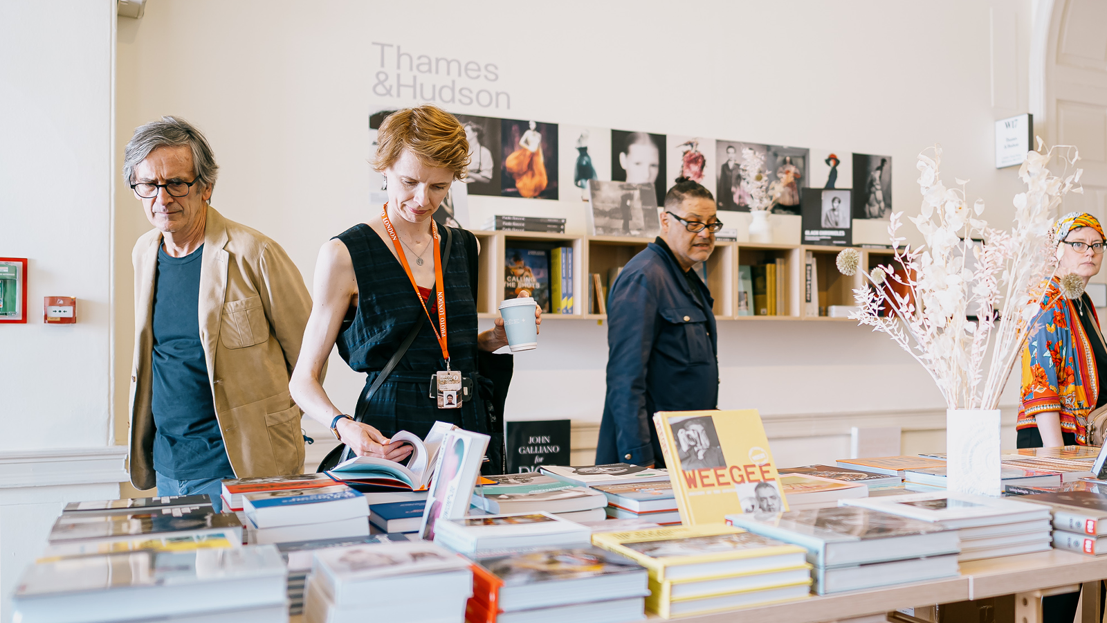 People engaging in photography books on display in Photo London