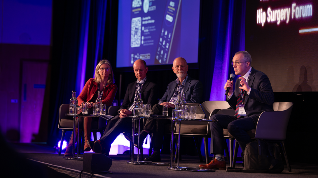 Four people on stage engaging in a panel discussion