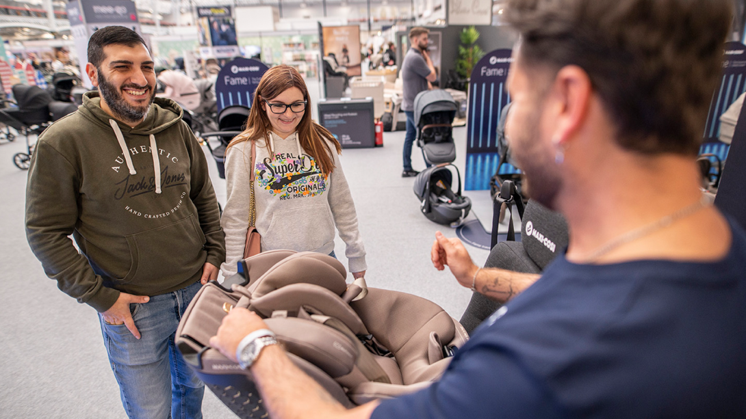 Three people testing out a Baby's car seat at The Baby Show