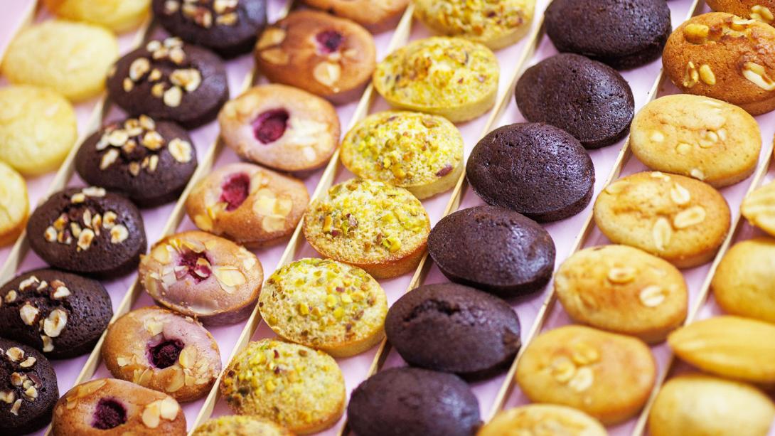 Assorted gourmet cookies displayed in neat rows, featuring a variety of flavors and toppings.