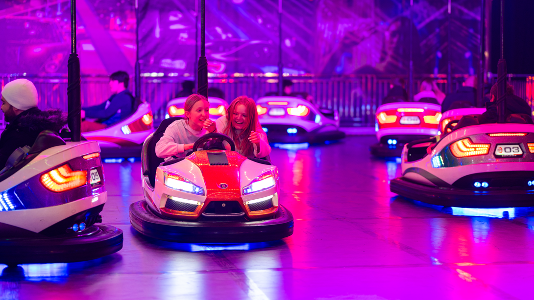 Two girls inside dodgems at funfair