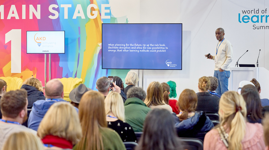 Man on stage presenting to a crowd