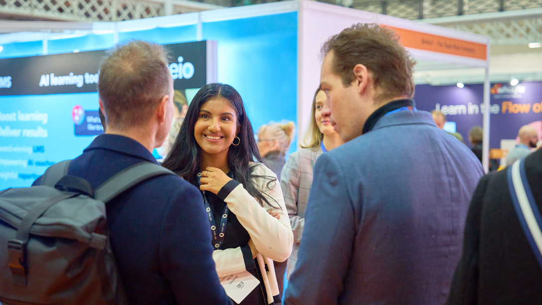 Women smiling talking to two males at an exhibition stand